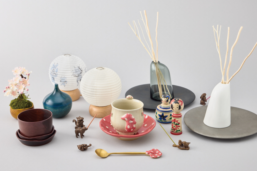 グレーの背景に並ぶ提灯・湯呑・花器・こけしなど日本各地の伝統的工芸品